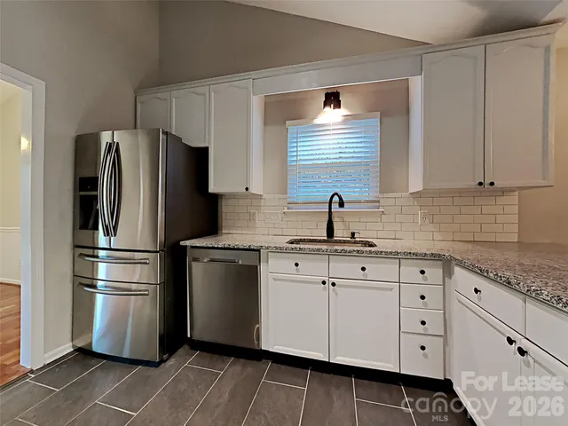 a kitchen with stainless steel appliances a refrigerator sink and cabinets