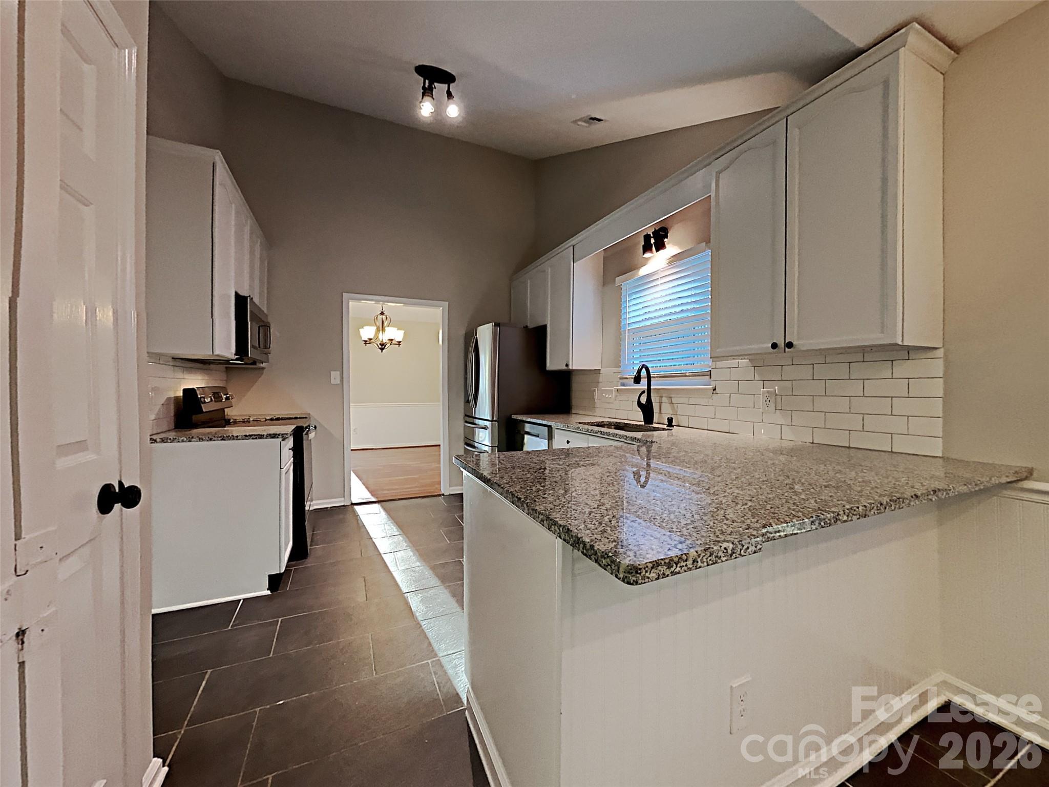 10715 Spruce Mountain Road Charlotte, NC 28214 - Photo 5 of 26 a kitchen with granite countertop a sink a counter top space and cabinets