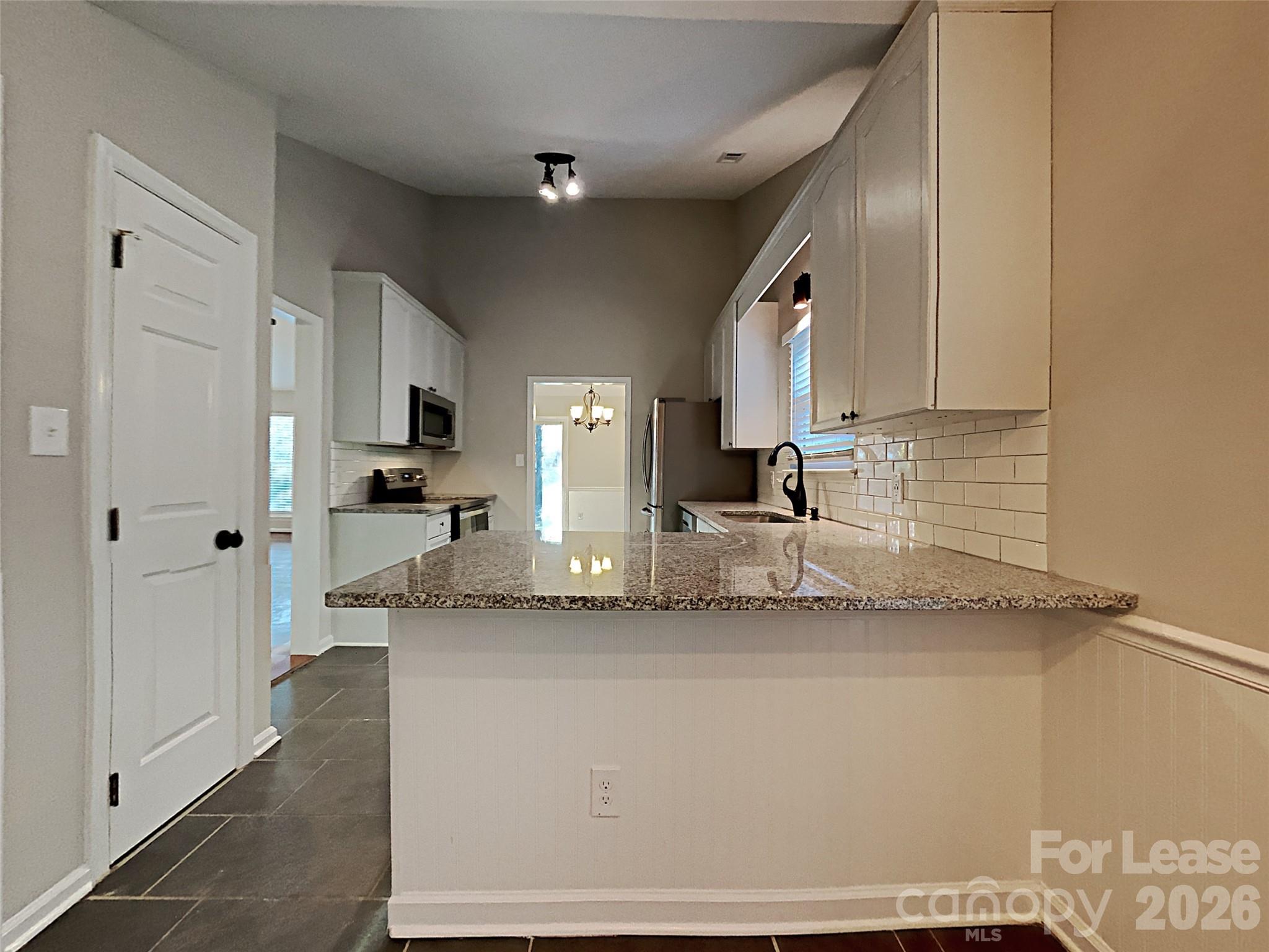 10715 Spruce Mountain Road Charlotte, NC 28214 - Photo 7 of 26 a kitchen with granite countertop a sink and a stove