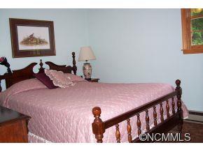 477 Rocky Top Road Maggie Valley, NC 28751 - Photo 13 of 20 a bedroom with a bed and a painting on the wall