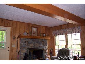 477 Rocky Top Road Maggie Valley, NC 28751 - Photo 9 of 20 a view of an empty room with a fireplace and a window