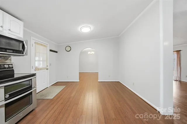 a view of a kitchen with wooden floor and electronic appliances