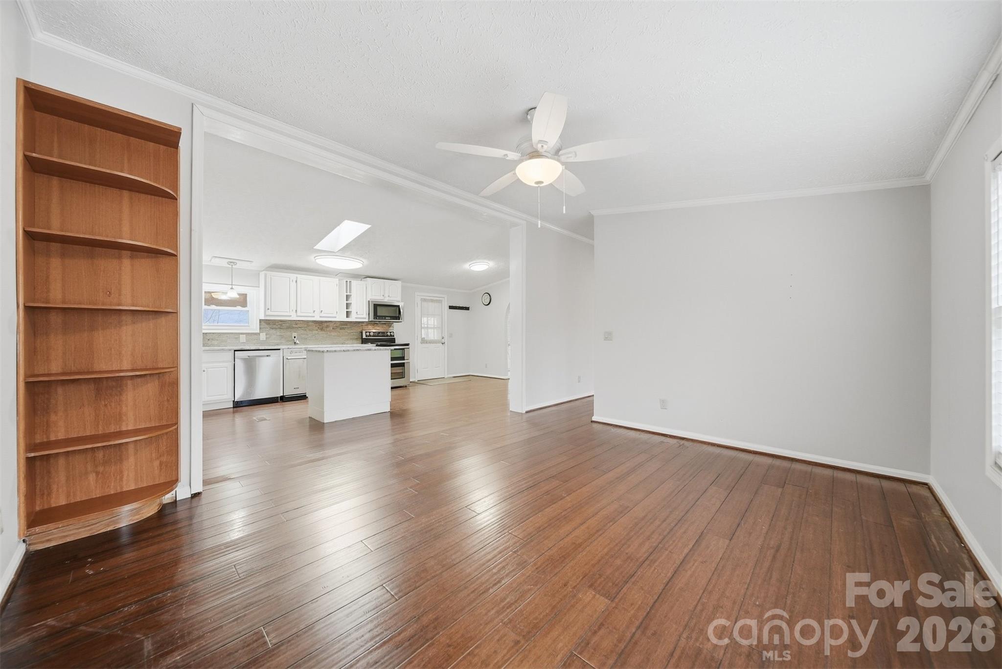 4915 Quartz Ridge Road Maiden, NC 28650 - Photo 13 of 38 an empty room with wooden floor kitchen view and a window