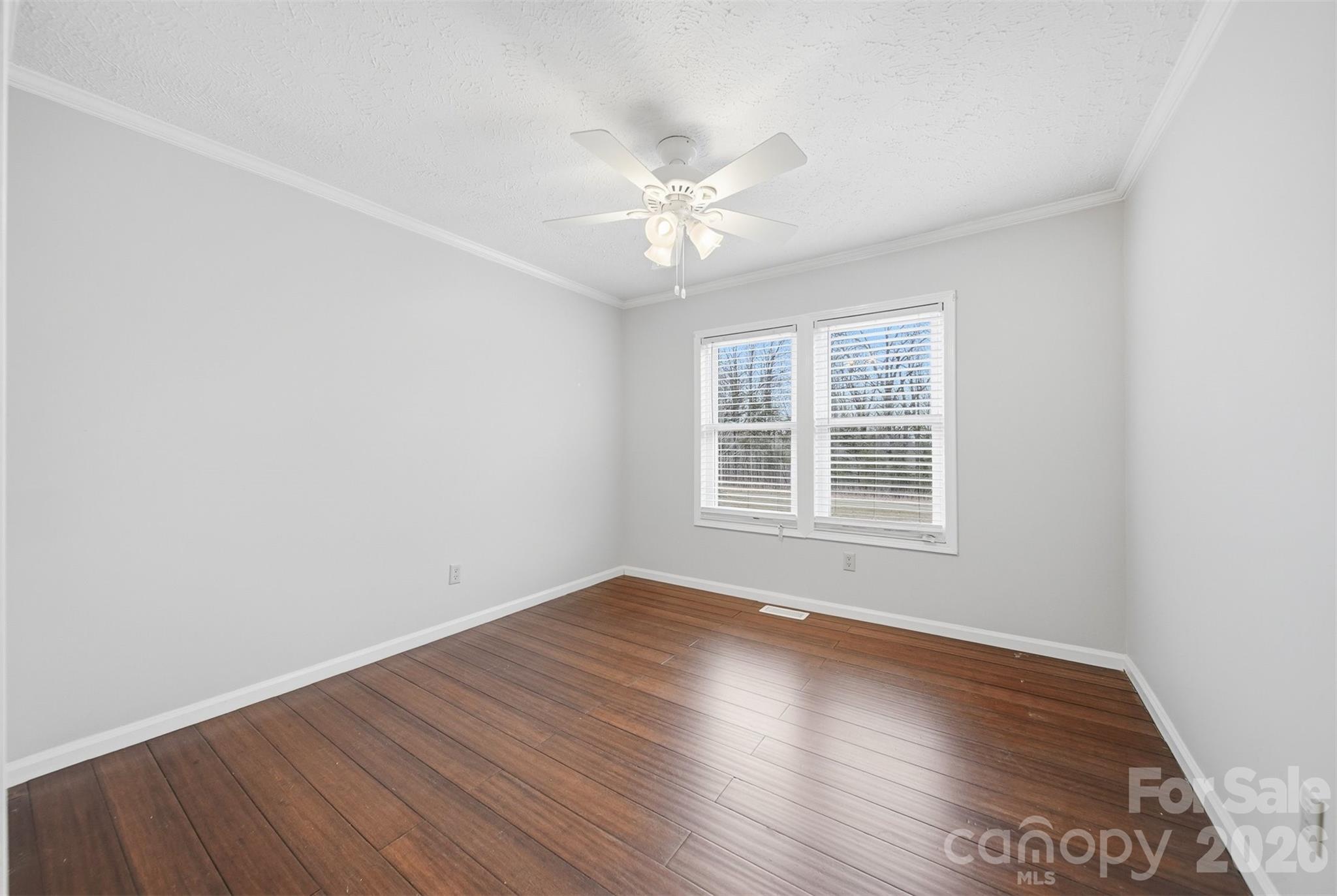 4915 Quartz Ridge Road Maiden, NC 28650 - Photo 23 of 38 an empty room with wooden floor fan and windows