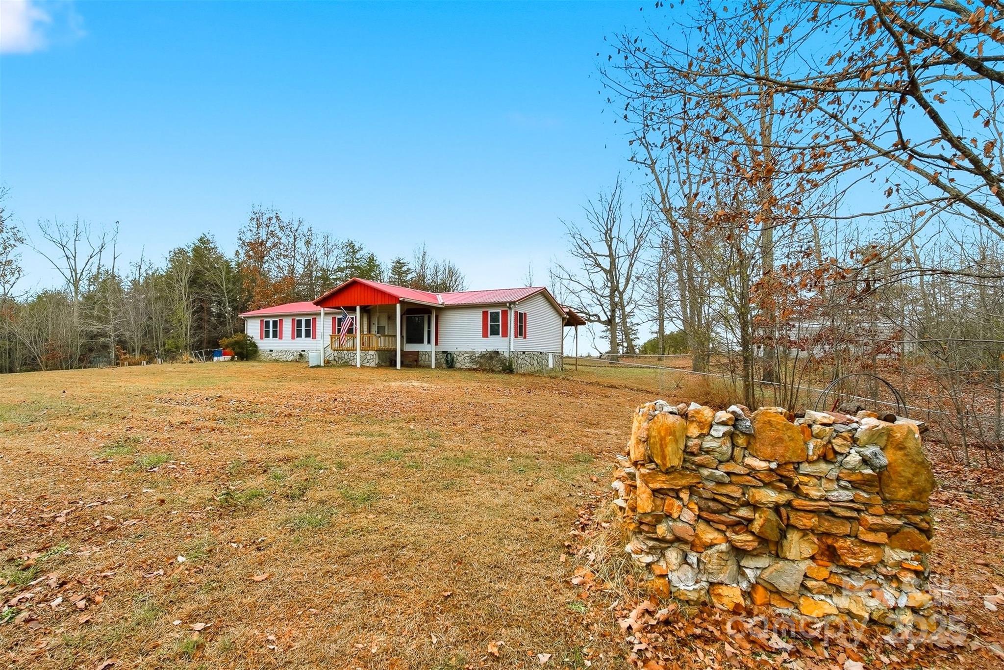 4915 Quartz Ridge Road Maiden, NC 28650 - Photo 4 of 38 a yellow and red house covered with tall trees