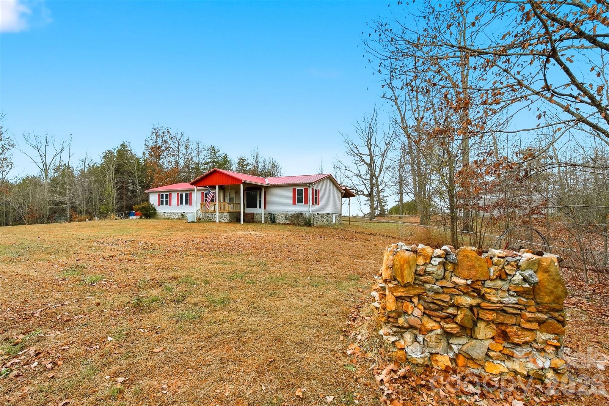 4915 Quartz Ridge Road Maiden, NC 28650 - Photo 5 of 38 a yellow and red house covered with tall trees