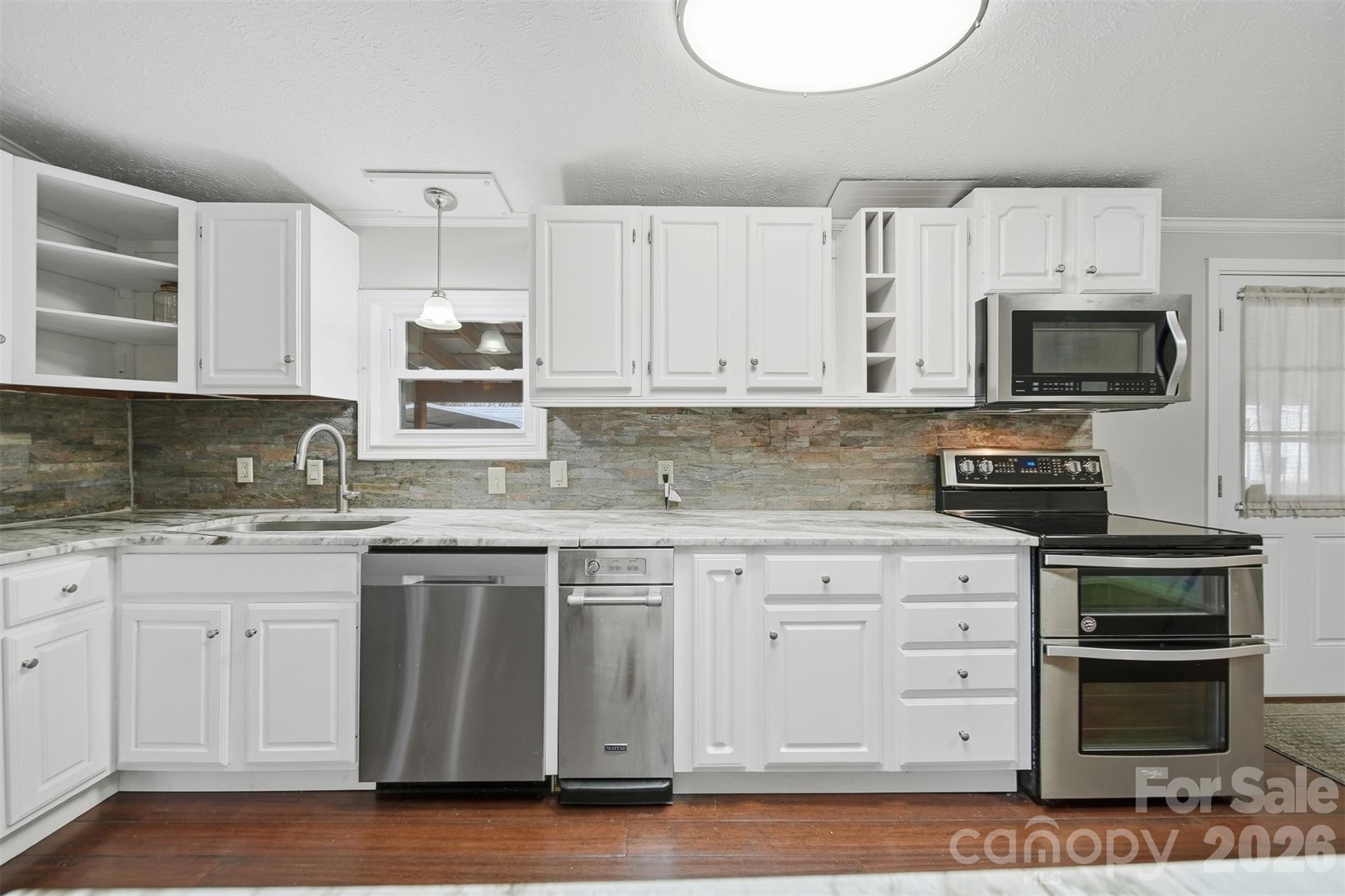 4915 Quartz Ridge Road Maiden, NC 28650 - Photo 6 of 38 a kitchen with granite countertop a sink and steel appliances