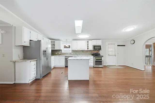 a kitchen with stainless steel appliances a refrigerator and a stove top oven