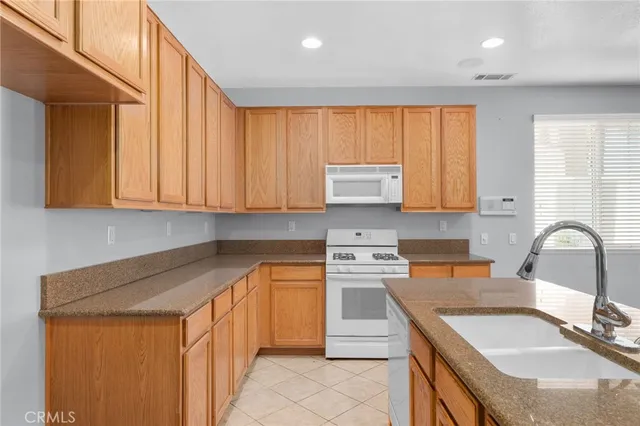 a kitchen with stainless steel appliances granite countertop a sink stove and cabinets