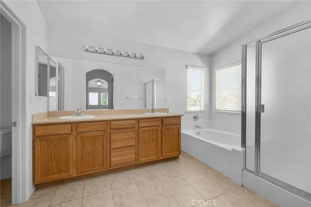 a spacious bathroom with a granite countertop sink mirror and a bathtub
