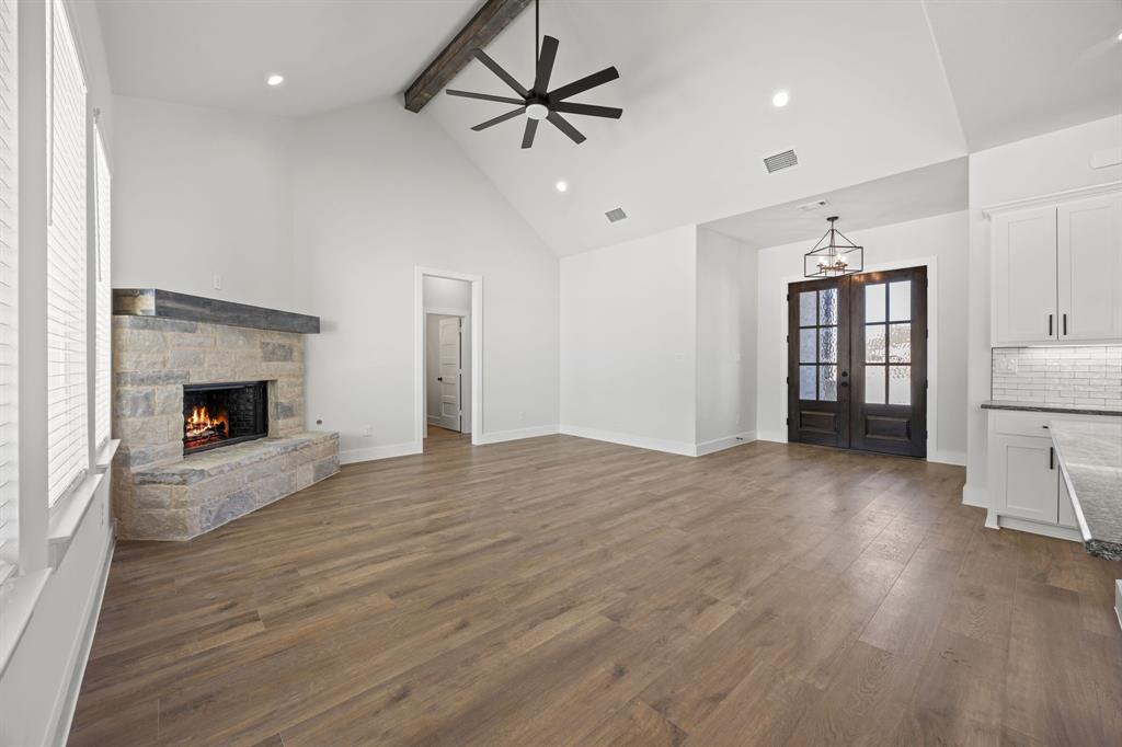 73 Dove Landing Rd Valley View Valley View, TX 76272 - Photo 12 of 30 Unfurnished living room featuring a stone fireplace, dark wood-style floors, a chandelier, and ceiling fan