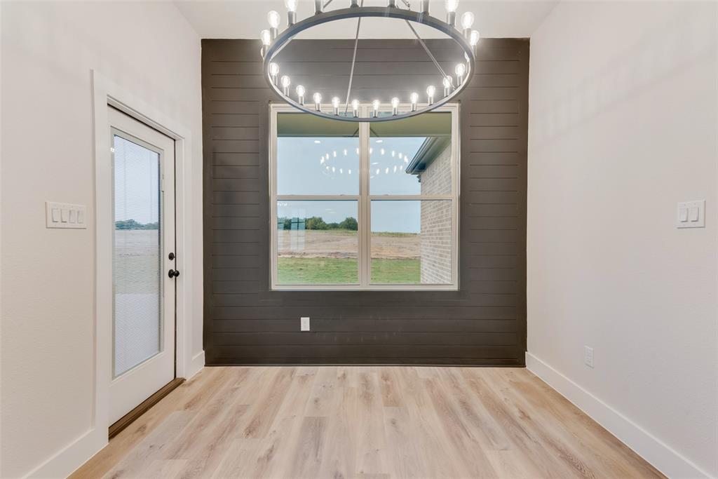 73 Dove Landing Rd Valley View Valley View, TX 76272 - Photo 14 of 34 Unfurnished dining area with wooden walls, light wood-style flooring, and plenty of natural light