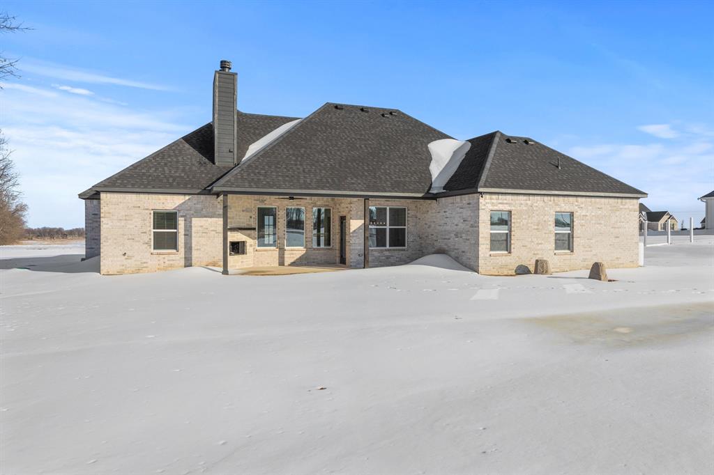 73 Dove Landing Rd Valley View Valley View, TX 76272 - Photo 28 of 30 Snow covered back of property featuring brick siding, a chimney, a patio, and a shingled roof