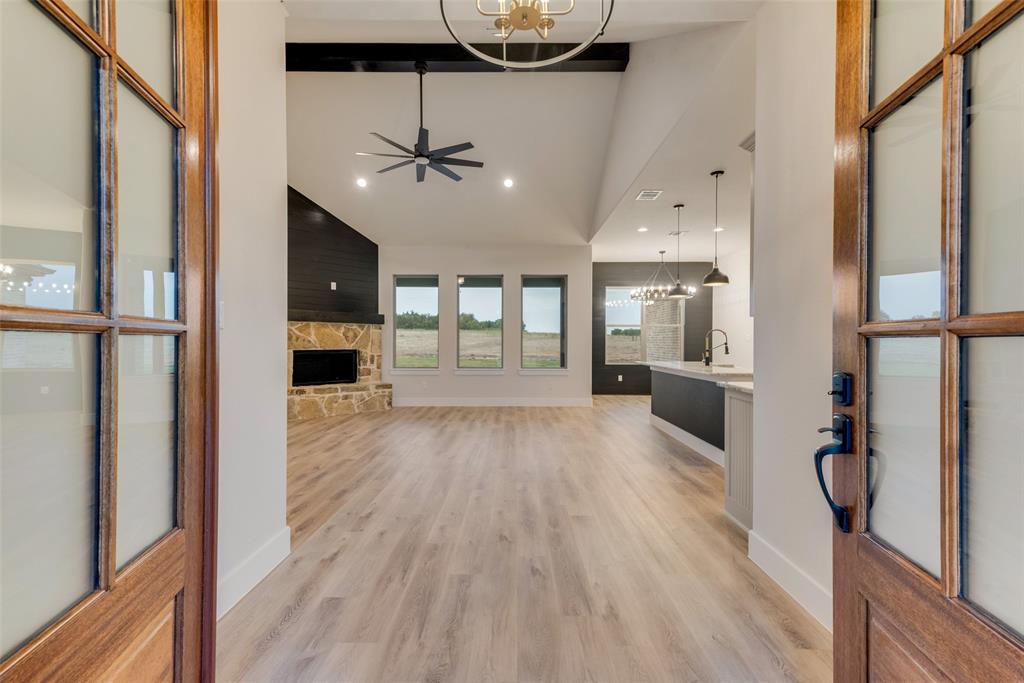 73 Dove Landing Rd Valley View Valley View, TX 76272 - Photo 5 of 34 Unfurnished living room featuring a chandelier, a fireplace, a ceiling fan, light wood finished floors, and recessed lighting