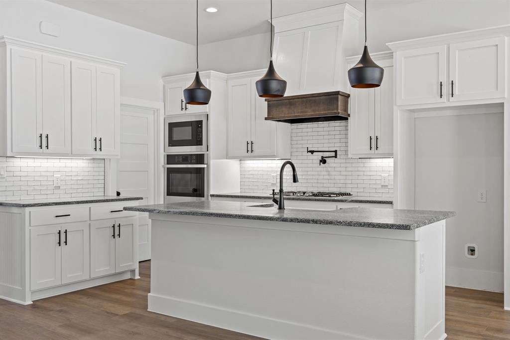 73 Dove Landing Rd Valley View Valley View, TX 76272 - Photo 5 of 30 Kitchen with dark stone counters, white cabinetry, dark wood-style floors, and stainless steel appliances
