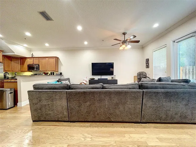 a living room with stainless steel appliances kitchen island granite countertop a sink a stove and a microwave