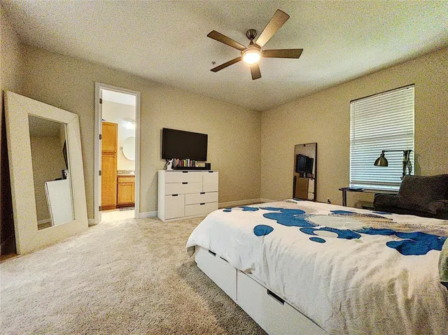 a bedroom with a bed and a flat tv screen on dresser