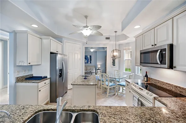a kitchen with stainless steel appliances granite countertop a refrigerator a stove microwave oven with a sink and dishwasher
