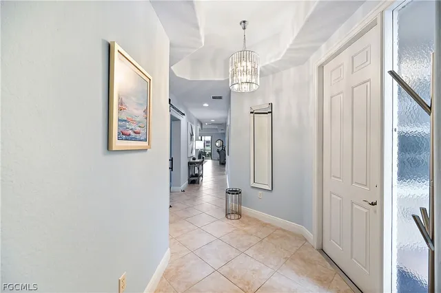 a view of a hallway with wooden floor and chandelier