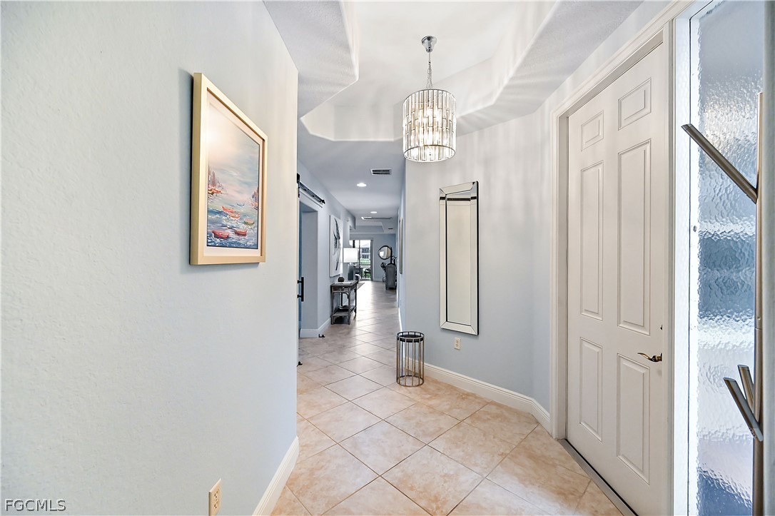 7832 Hawthorne Drive, Unit 1901 Naples, FL 34113 - Photo 14 of 26 a view of a hallway with wooden floor and chandelier