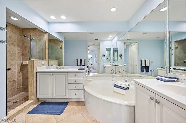 a large white bathroom with a double vanity sink a mirror and a shower