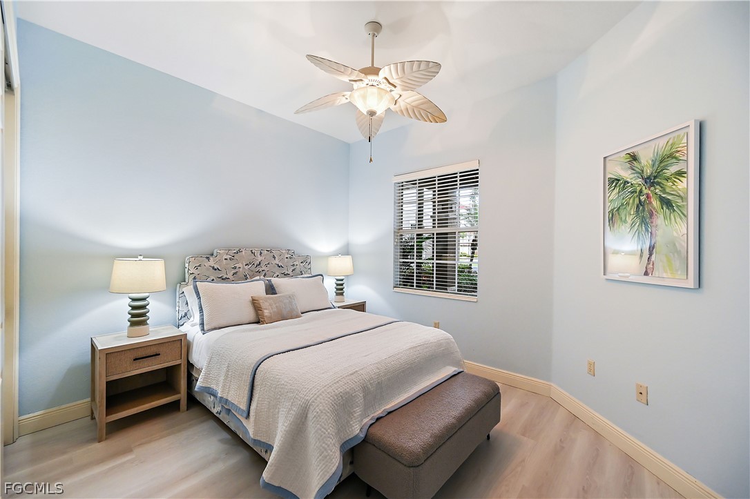 7832 Hawthorne Drive, Unit 1901 Naples, FL 34113 - Photo 19 of 26 a bedroom with a bed and a chandelier