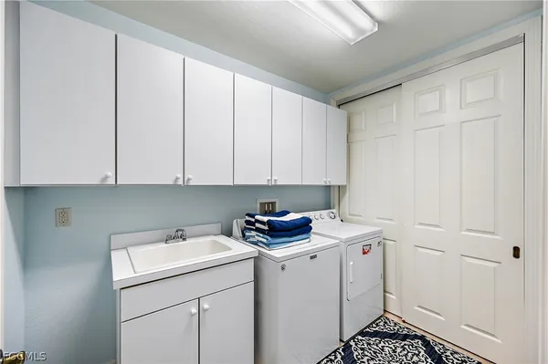 a utility room with sink dryer and washer