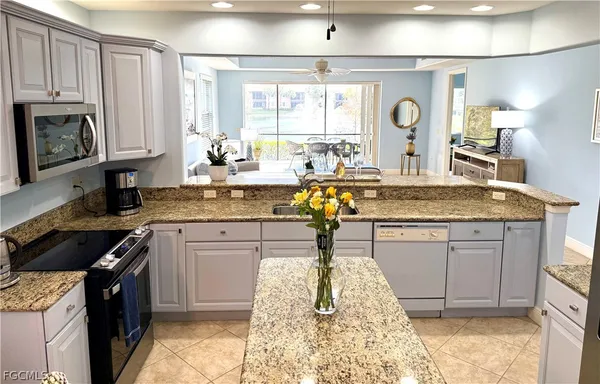 a kitchen with granite countertop a sink stainless steel appliances and cabinets