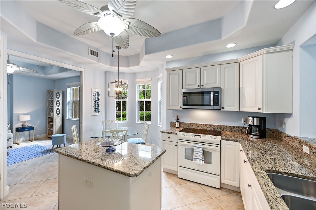 7832 Hawthorne Drive, Unit 1901 Naples, FL 34113 - Photo 10 of 26 a kitchen with stainless steel appliances granite countertop a sink stove and refrigerator