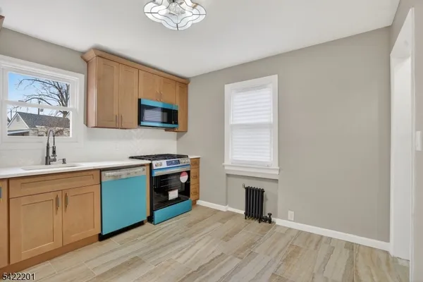a view of a kitchen with a sink wooden cabinets and a window