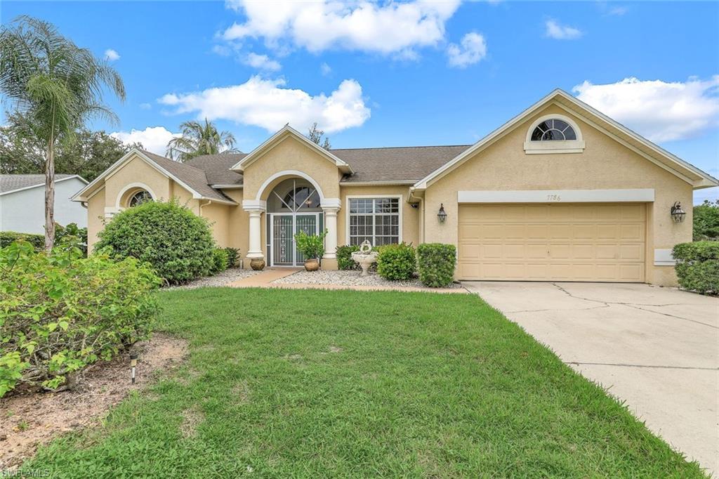 7786 Scarlet Court Naples, FL 34104 - Photo 1 of 19 a front view of a house with a yard and garage