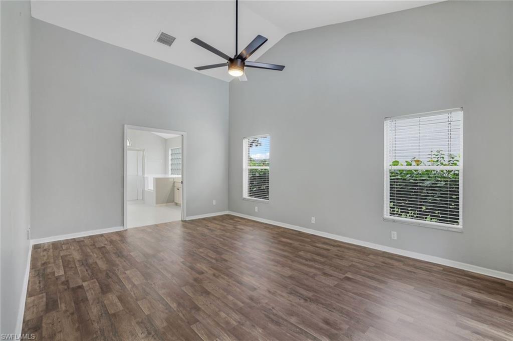 7786 Scarlet Court Naples, FL 34104 - Photo 11 of 19 a view of an empty room with wooden floor and a window