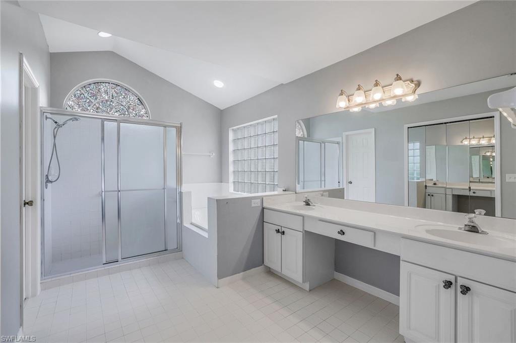 7786 Scarlet Court Naples, FL 34104 - Photo 13 of 19 a spacious bathroom with a double vanity sink a mirror and a bathtub