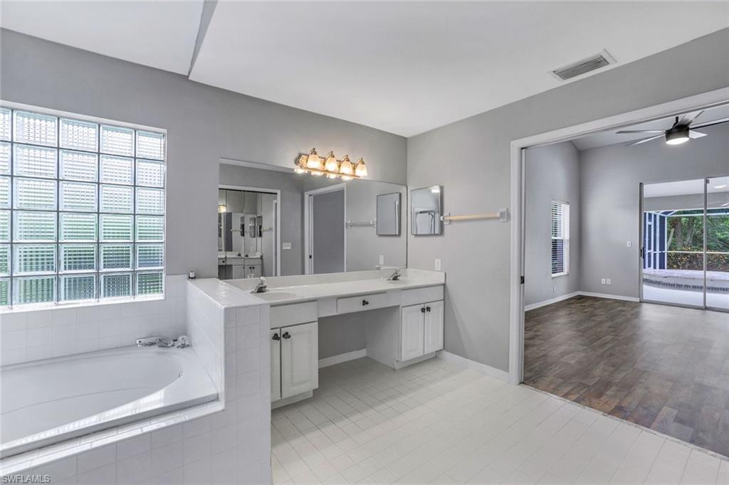 7786 Scarlet Court Naples, FL 34104 - Photo 14 of 19 a spacious bathroom with a tub sink and mirror