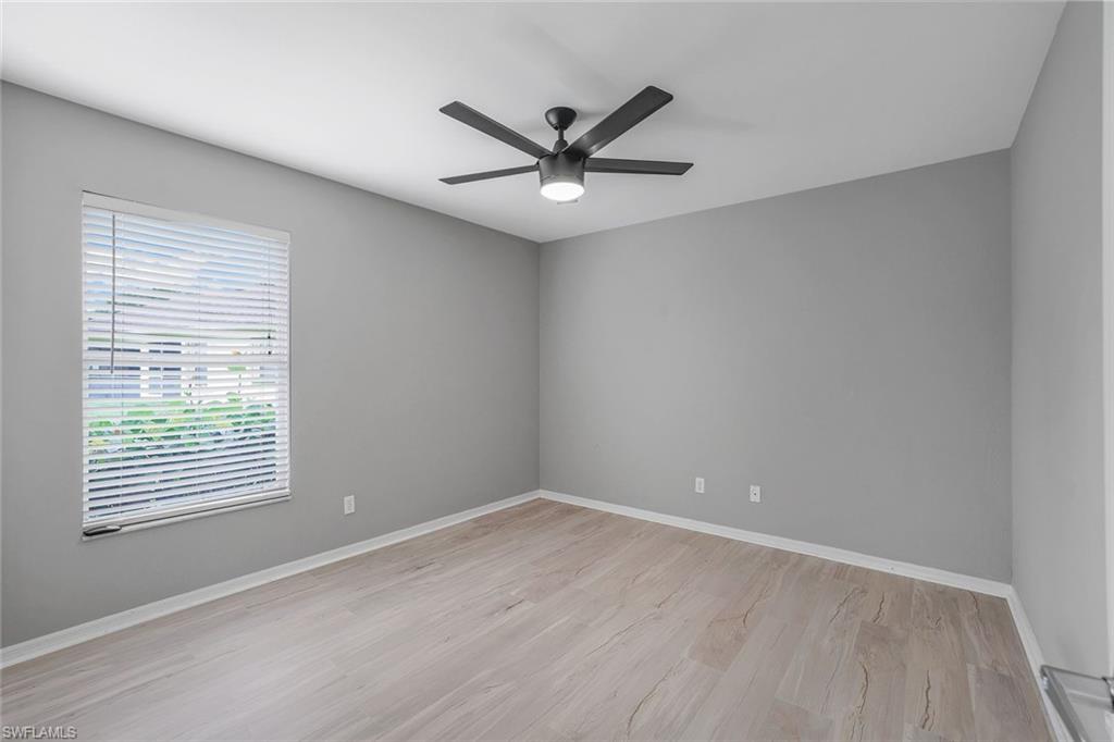 7786 Scarlet Court Naples, FL 34104 - Photo 15 of 19 wooden floor in an empty room with a window