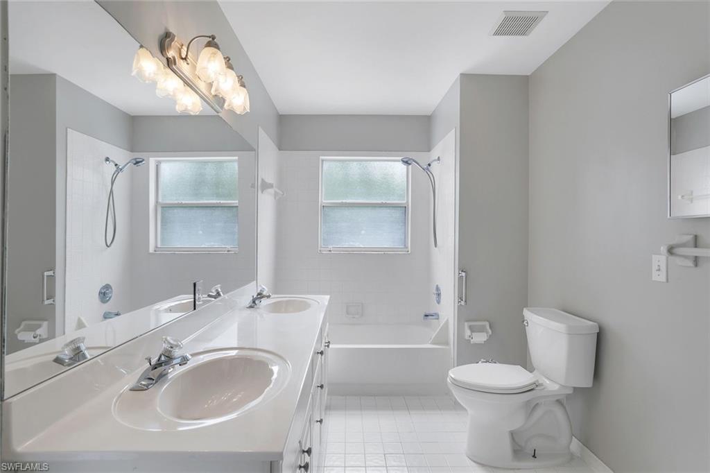 7786 Scarlet Court Naples, FL 34104 - Photo 16 of 19 a bathroom with a sink toilet a mirror and shower