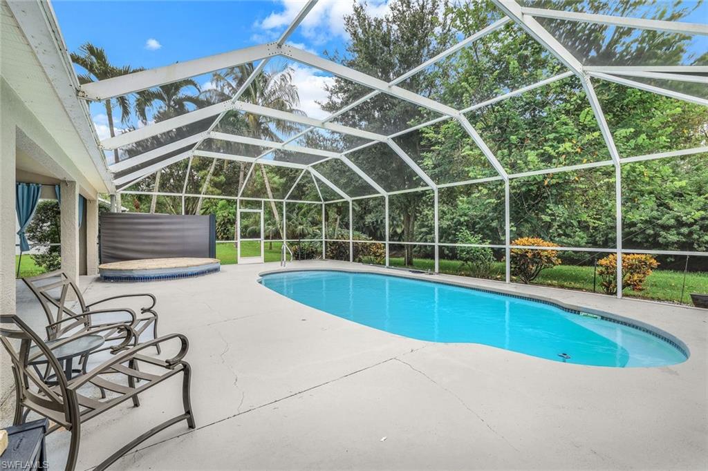 7786 Scarlet Court Naples, FL 34104 - Photo 19 of 19 a view of a backyard with a swimming pool and sitting area