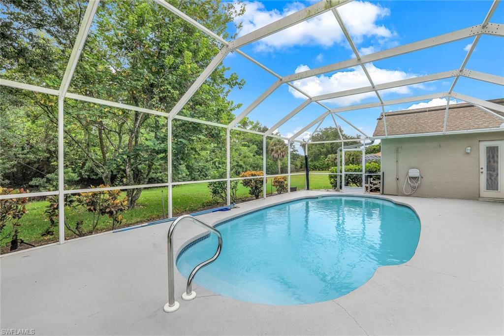 7786 Scarlet Court Naples, FL 34104 - Photo 2 of 19 a view of a backyard with a swimming pool