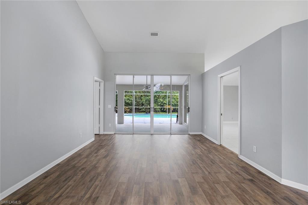 7786 Scarlet Court Naples, FL 34104 - Photo 3 of 19 wooden floor in an empty room with a window