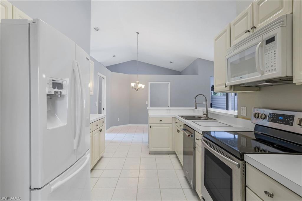 7786 Scarlet Court Naples, FL 34104 - Photo 8 of 19 a kitchen with stainless steel appliances granite countertop a sink and cabinets