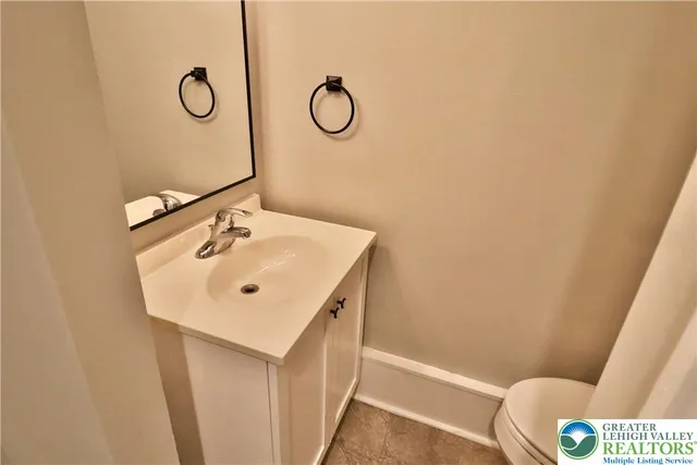 a bathroom with a sink mirror vanity and toilet