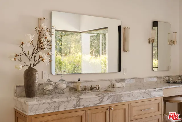 a bathroom with a granite countertop sink and a mirror