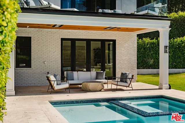 a view of a house with swimming pool and sitting area