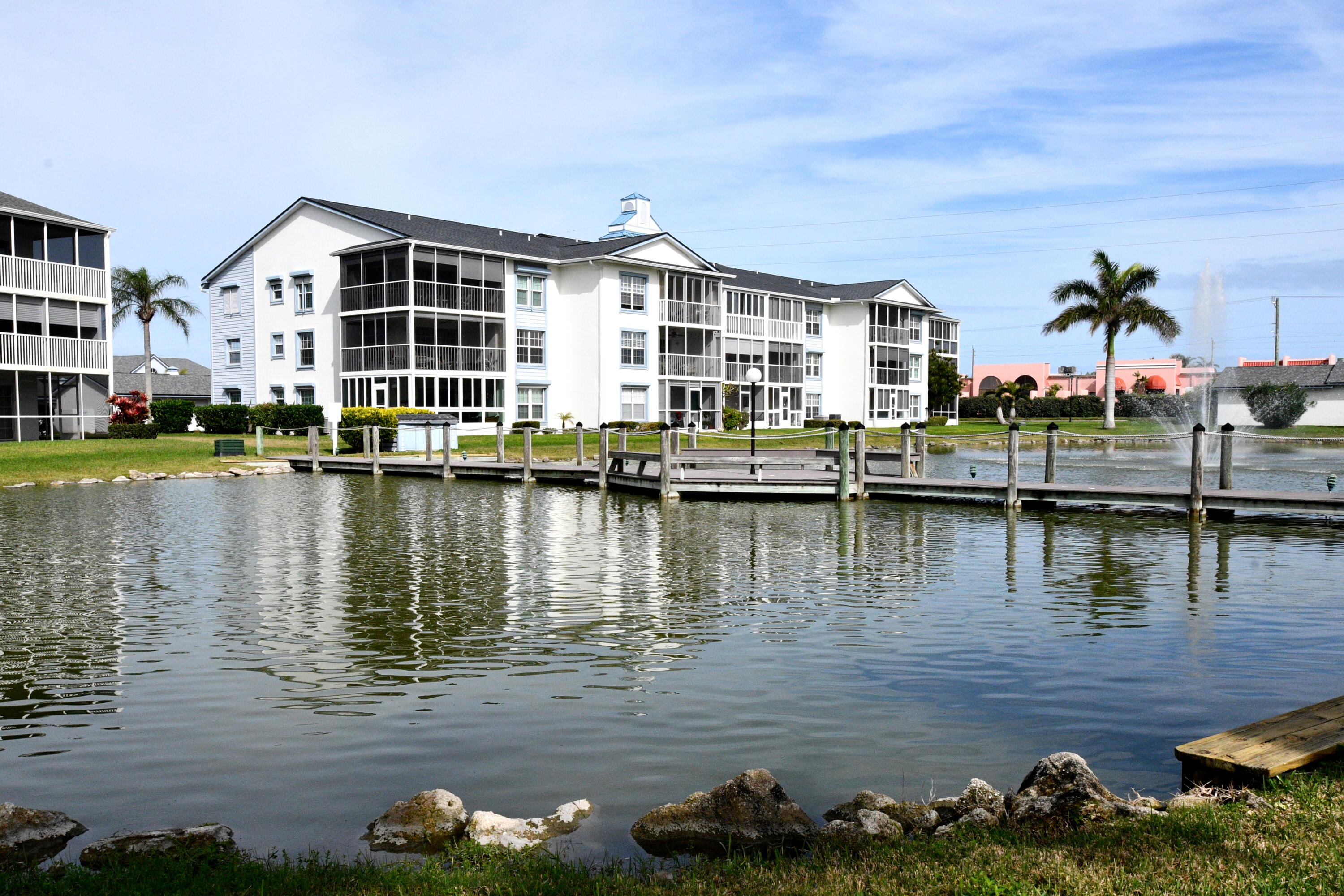 a view of a lake with a building and large trees