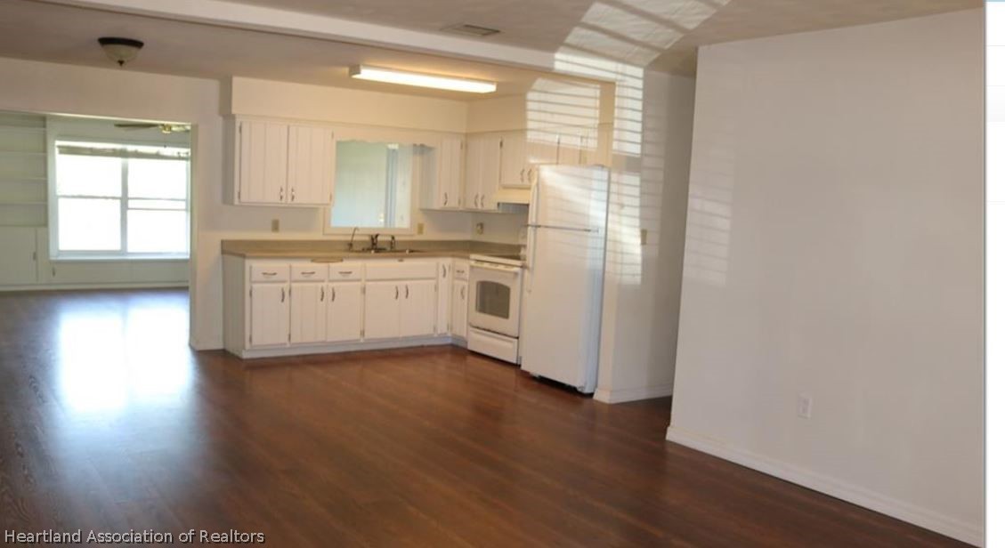 121 Longview Road Sebring, FL 33870 - Photo 3 of 5 a kitchen with stainless steel appliances granite countertop a stove a sink and a window