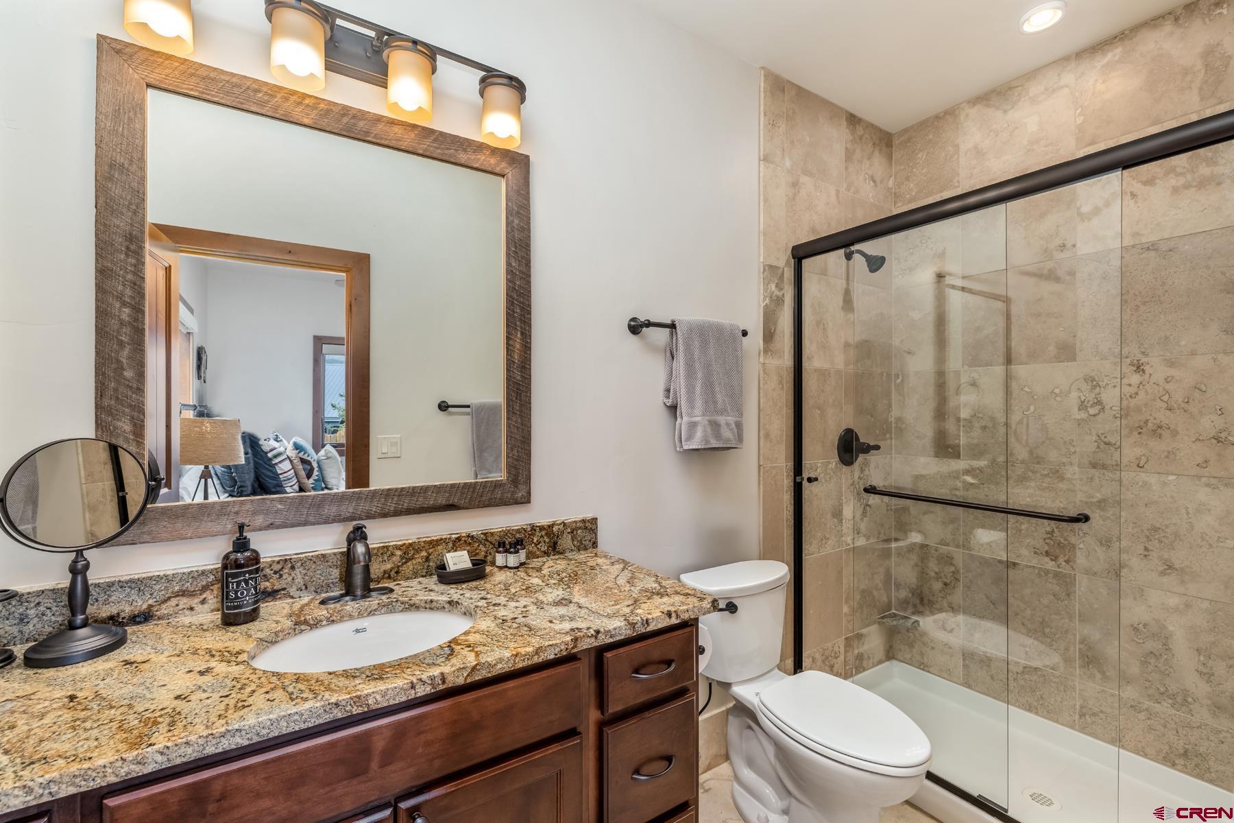 32 Cinnamon Mountain Road Crested Butte, CO 81225 - Photo 19 of 44 a bathroom with a granite countertop sink a toilet and shower