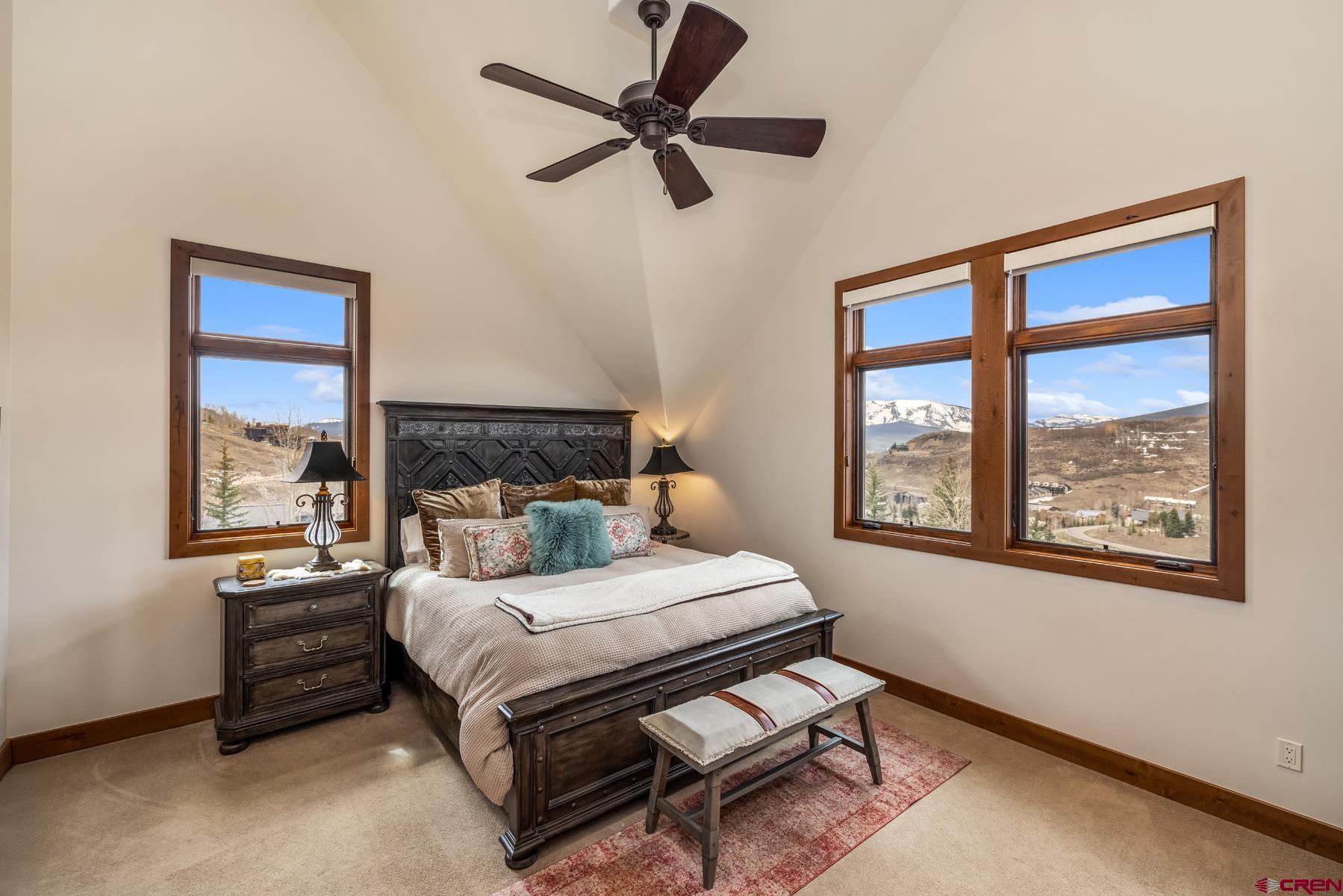 32 Cinnamon Mountain Road Crested Butte, CO 81225 - Photo 21 of 44 a bedroom with a bed a window and a chandelier