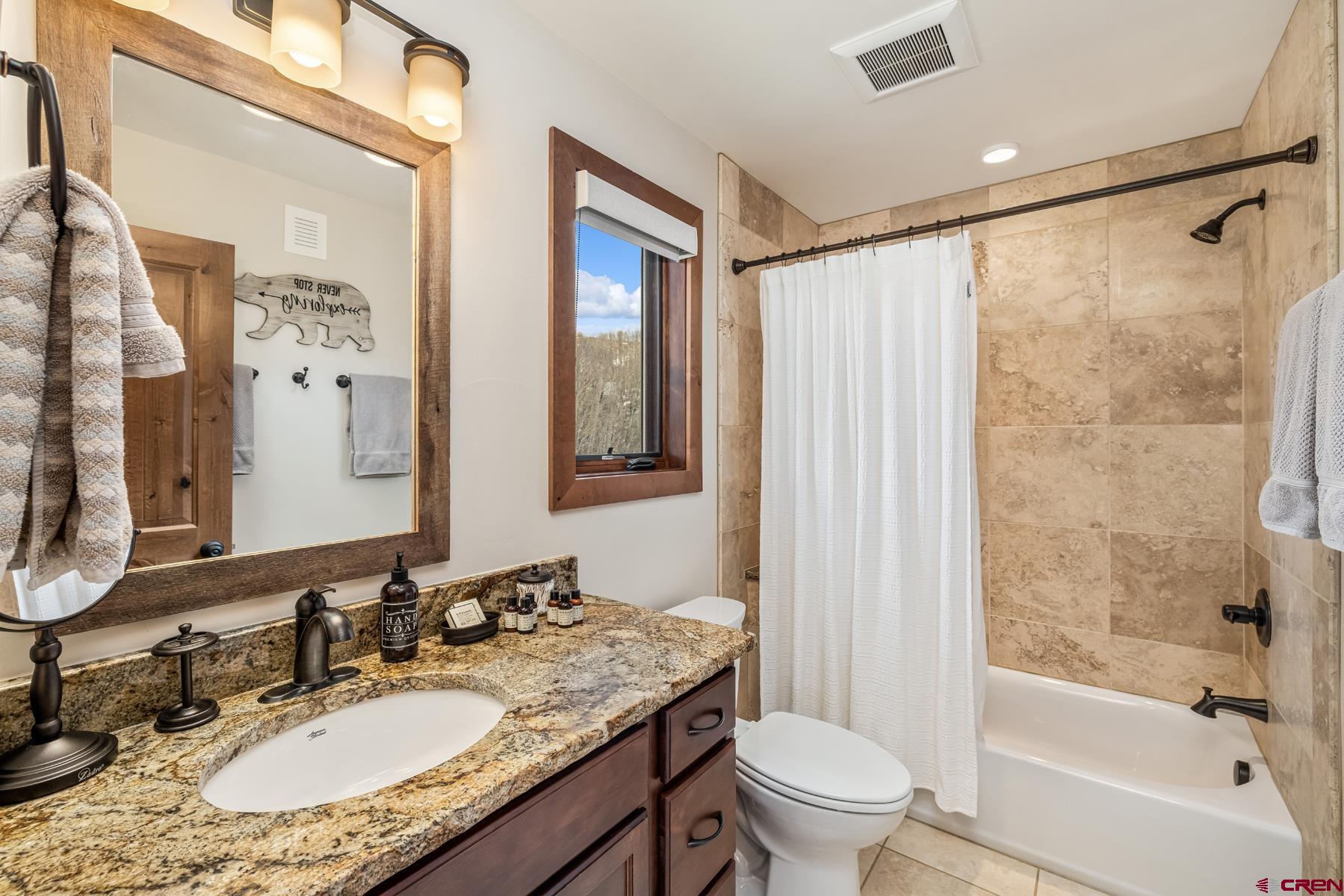 32 Cinnamon Mountain Road Crested Butte, CO 81225 - Photo 28 of 44 a bathroom with a granite countertop sink a toilet a mirror a vanity and shower