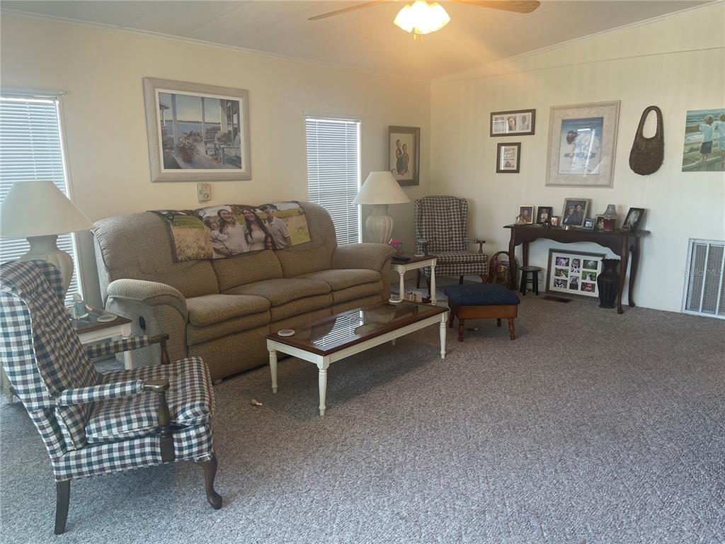 4179 Rolling Oaks Drive Winter Haven, FL 33880 - Photo 11 of 31 a living room with furniture a couch and paintings on the wall