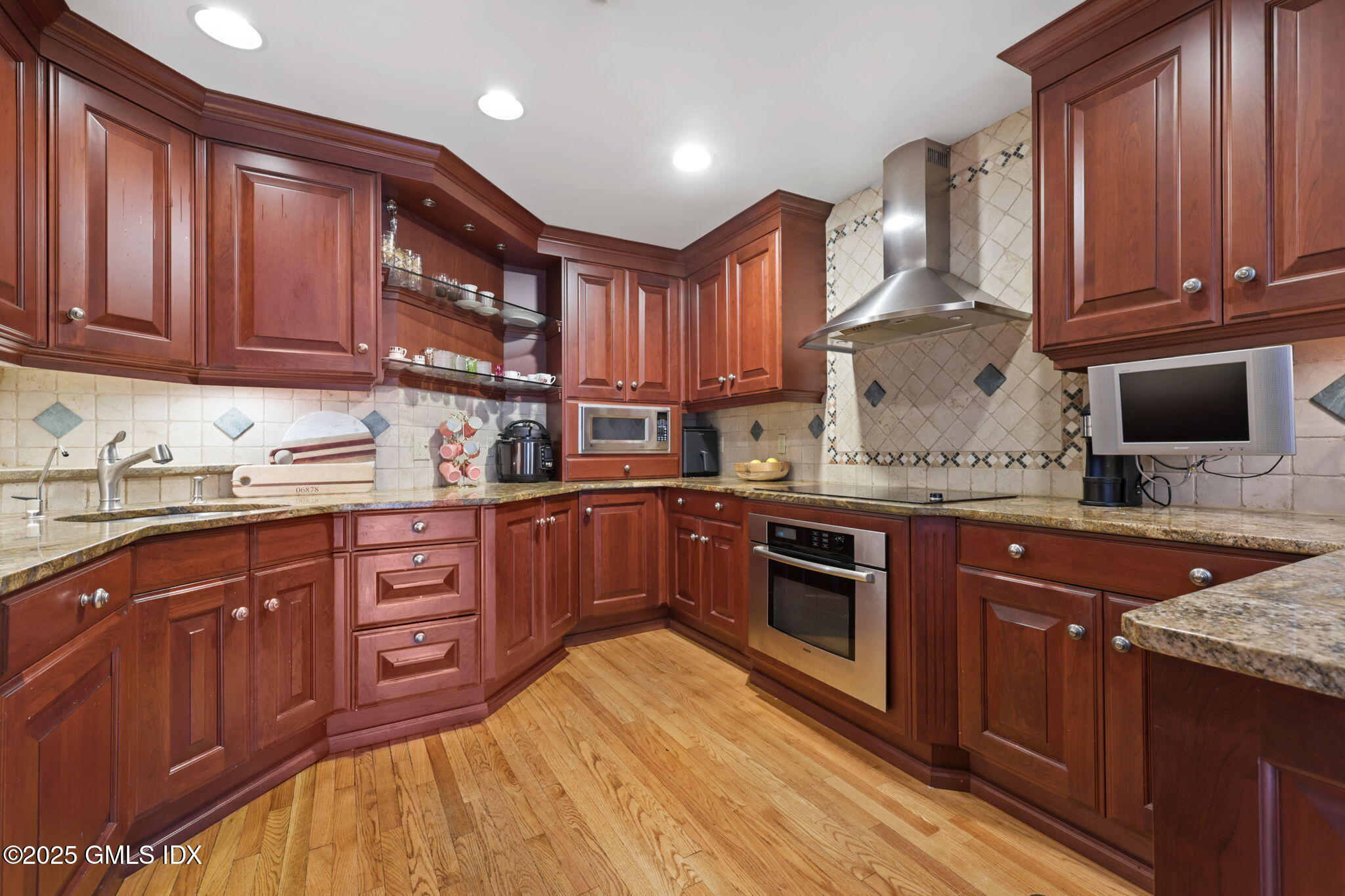 333 Palmer Hill Road, Unit 2E Riverside, CT 06878 - Photo 8 of 21 a kitchen with granite countertop wooden cabinets and stainless steel appliances